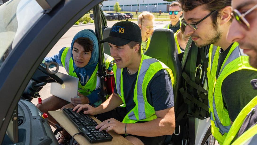 Students working in a model vehicle