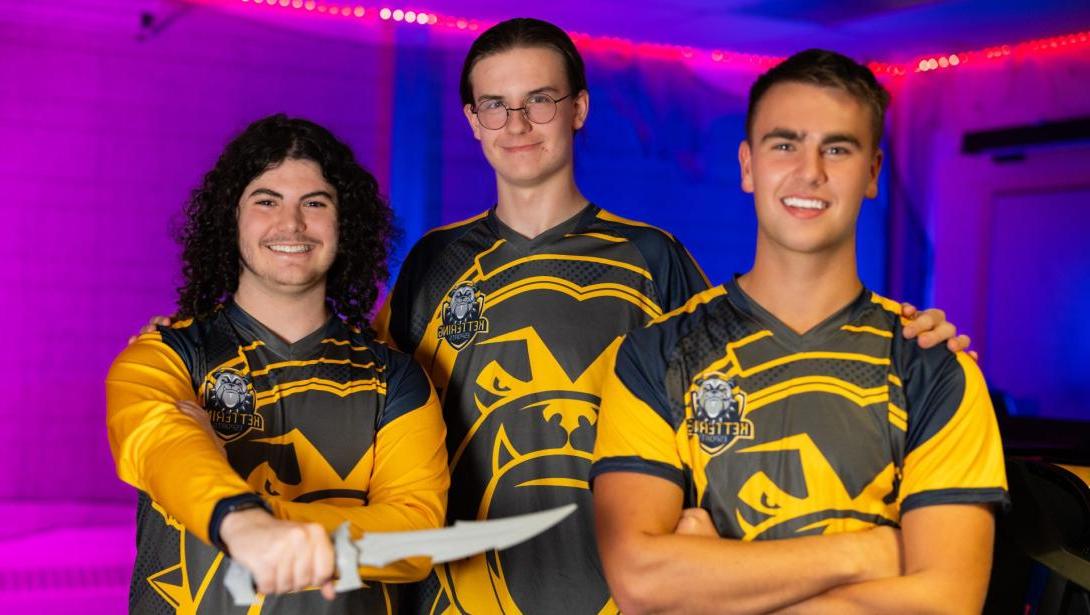 Three members of the esports team wearing jerseys