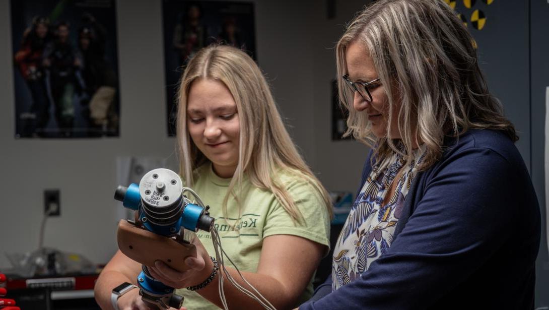 Two individuals work with equipment in the Crash Lab